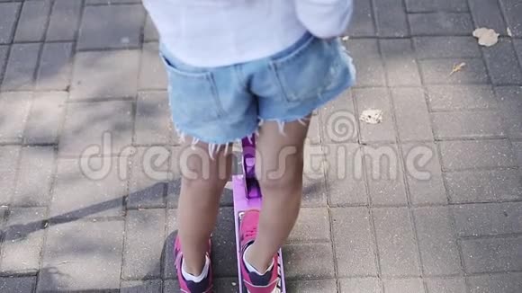 夏天骑滑板车的孩子的脚特写视频的预览图