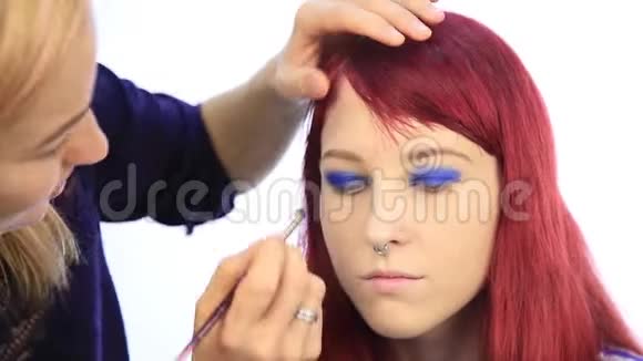 化妆师和模特一起工作艺术家用特殊画笔手的特写镜头视频的预览图