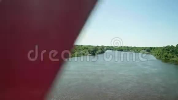 从火车的窗户看到绿树火车上桥慢镜头视频的预览图