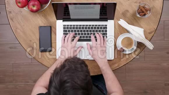 一位年轻的商人在键盘上打字时的俯视图视频的预览图