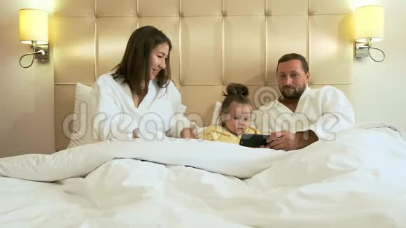 酒店客房配有智能手机的幸福家庭视频的预览图