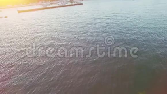 在阳光明媚的夜晚游艇在海湾航行在无人驾驶飞机上射击视频的预览图
