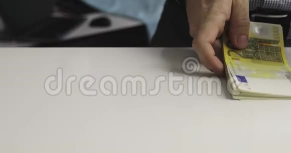 男手把一捆钱放在桌子上视频的预览图