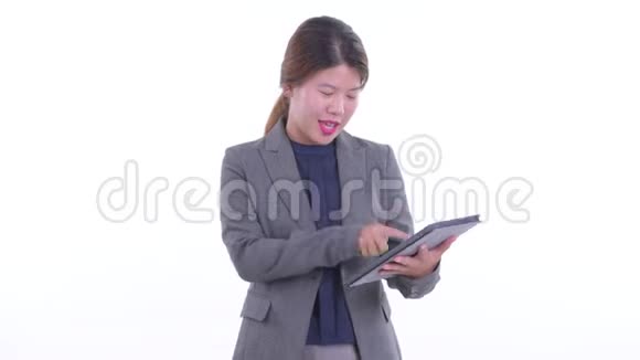 快乐年轻的亚洲女商人用数码平板电脑说话视频的预览图