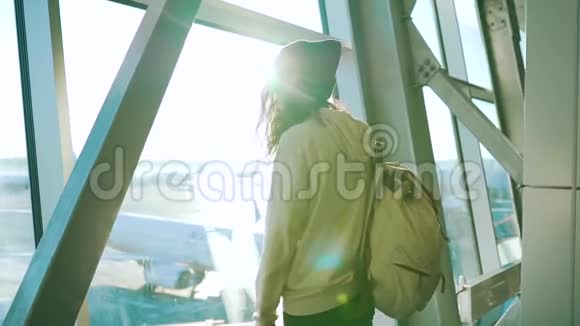 女孩站在机场候机楼的窗口视频的预览图