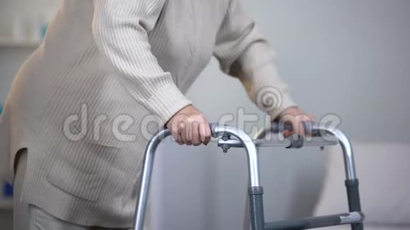 老年妇女使用步行架关节创伤后康复关闭视频的预览图