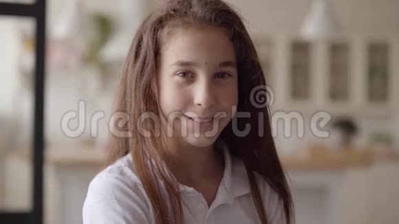 可爱的小女孩看着镜头开心地笑着的肖像无忧无虑的童年家里的小感情女孩实际视频的预览图