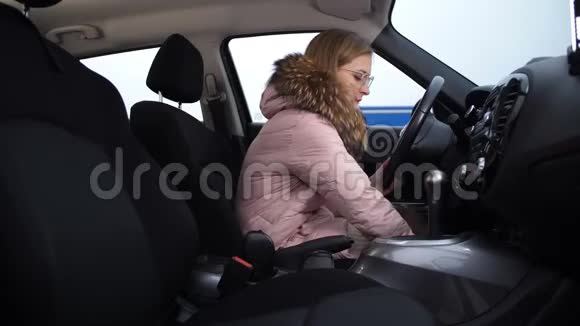 金发女孩转动汽车的方向盘换挡关掉汽车下车视频的预览图