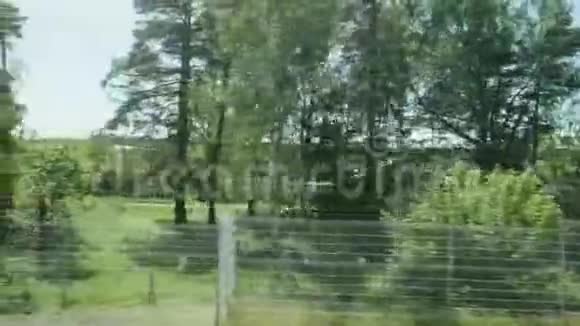 背光树木和村庄在乡间道路上篱笆预制动物进入铁路从移动窗口的视图视频的预览图