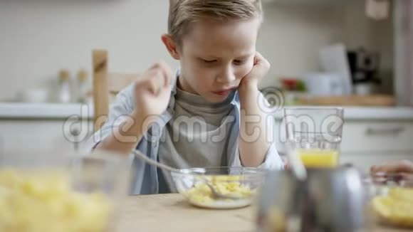 男孩试图吃他最不喜欢的菜而他的母亲给他妹妹加果汁视频的预览图