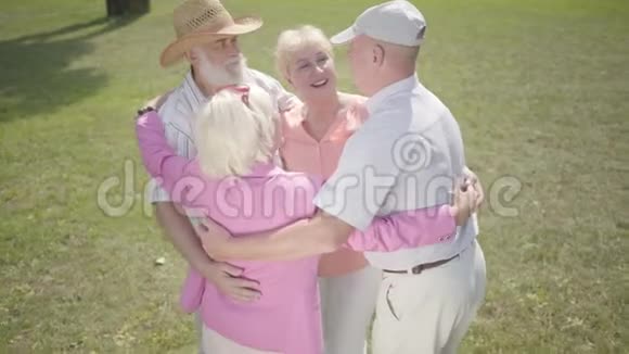 两对老夫妇在公园里拥抱在一起围成一圈双人约会的高级夫妇友好的公司休息视频的预览图