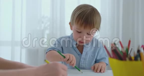 男孩画了一幅铅笔画画的是一个幸福的家庭坐在桌子旁视频的预览图
