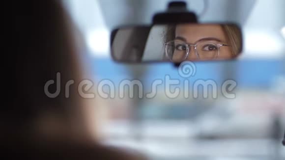 射在车上反射在前镜漂亮的戴眼镜的女眼睛环顾四周视频的预览图