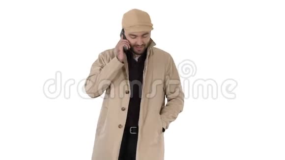 穿着壕沟的人在白色背景下行走时打商务电话视频的预览图
