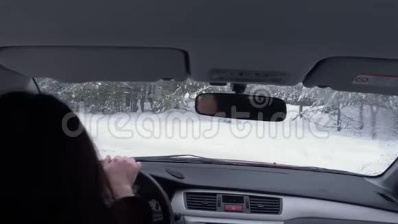 在越野的冬季森林里开车的女人视频的预览图