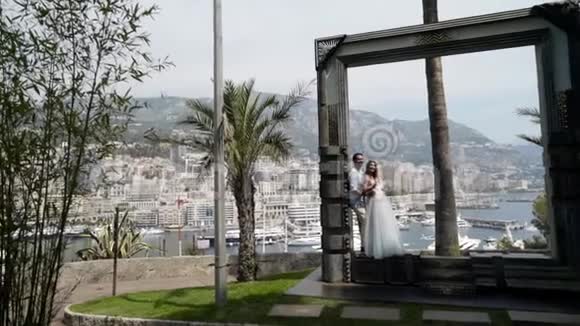 度假小镇背景上的一对漂亮夫妇行动城市背景下年轻夫妇的婚纱照视频的预览图