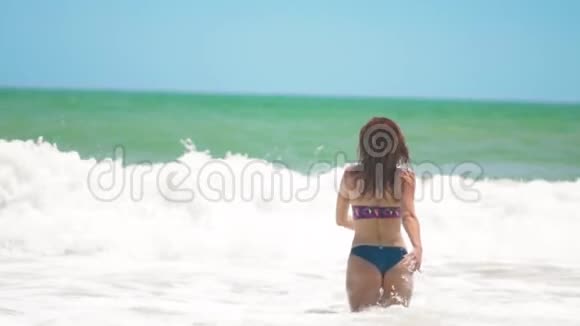 年轻快乐的女人跑进大海溅了很多水花跳过巨浪视频的预览图