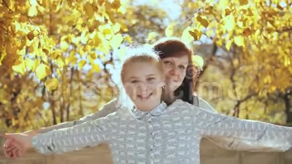 快乐的母亲在秋天公园拥抱她的女儿视频的预览图