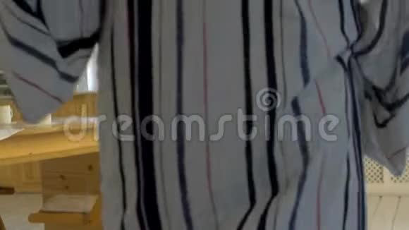一个早晨的男人穿着一件条纹礼服早晨房间里的日光视频的预览图