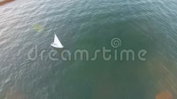 在日落时游艇通过海浪的高角度鸟瞰视频的预览图