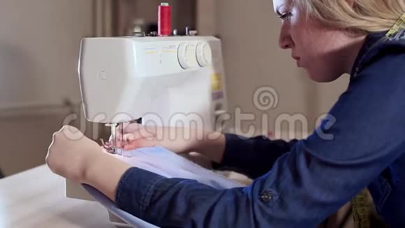 一位年轻的女裁缝在家工作准备布料开始缝纫缝纫机视频的预览图