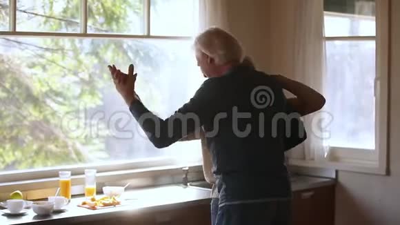 快乐成熟的老夫妇在厨房里欢笑视频的预览图
