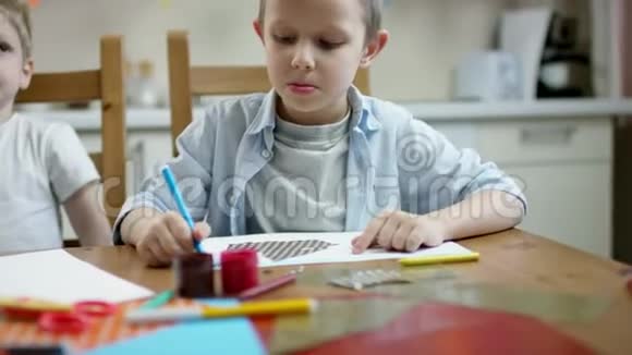 男孩用钢笔用流动照相机画正确的画视频的预览图