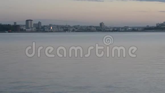 夏季在伏尔加河上空傍晚从对面的河岸眺望Cheboksary市视频的预览图