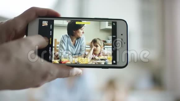 镜头显示有人在电话里拍了一张母亲和女儿的滑稽照片视频的预览图