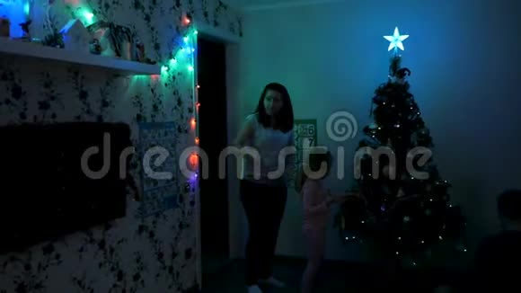一家人在黑暗中点亮圣诞树视频的预览图
