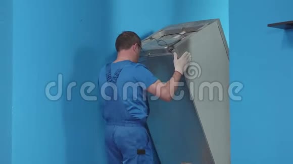 穿制服的男人在厨房里带冰箱视频的预览图