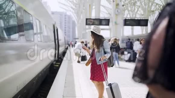带智能手机的女士在火车附近视频的预览图