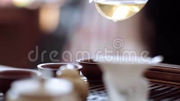 在木桌上的茶杯里倒了一杯香茗茶道仪式视频的预览图