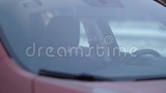 从挡风玻璃上看女孩上车系好安全带开动汽车视频的预览图