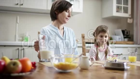 妈妈给女儿在盛满玉米片的碗里加牛奶但她拒绝视频的预览图