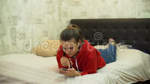 在床上使用智能手机的少女视频的预览图