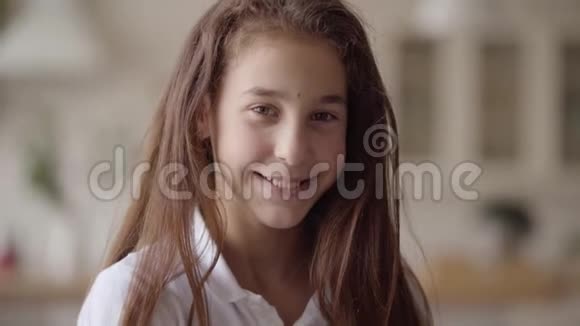 可爱的小女孩看着镜头开心地笑着的肖像无忧无虑的童年家里的小感情女孩实际视频的预览图