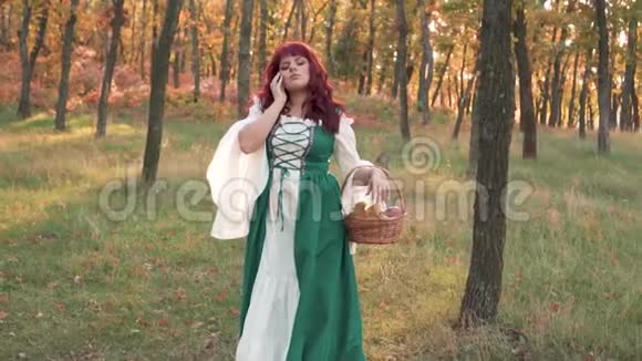 秋黄林中可爱的毛茸茸的大女人手里拿着一篮子落叶和一个多汁的苹果视频的预览图