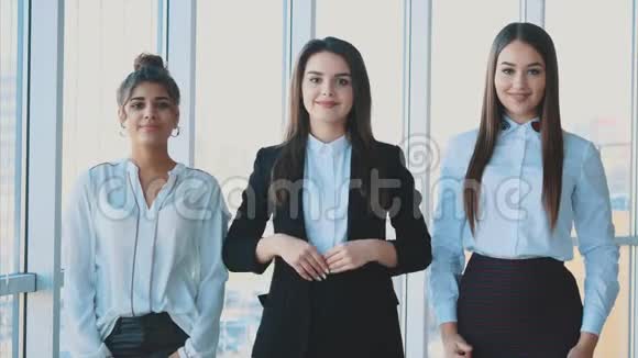 三只女商人的手紧握在一起展示了她们在商界的有效融合和成功视频的预览图