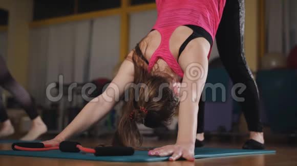 两个女人在健身房做普拉提练习伸展肌肉参加特殊运动垫的女孩视频的预览图