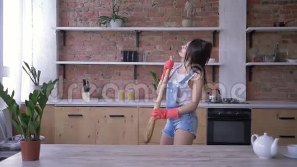 家务活有趣的女管家玩得开心在打扫卫生时像麦克风一样唱歌视频的预览图