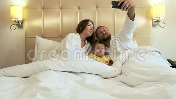幸福的一家人在床上准备晚上睡觉视频的预览图