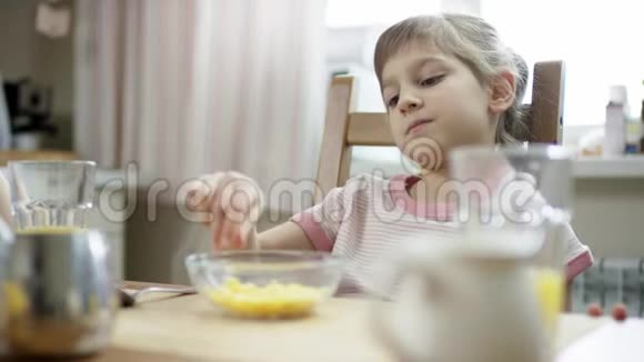 女孩坐着等着吃一顿饭把玉米片合上视频的预览图