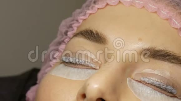 美容院的专业睫毛增强在一个年轻女人的脸上涂上了特殊的睫毛视频的预览图
