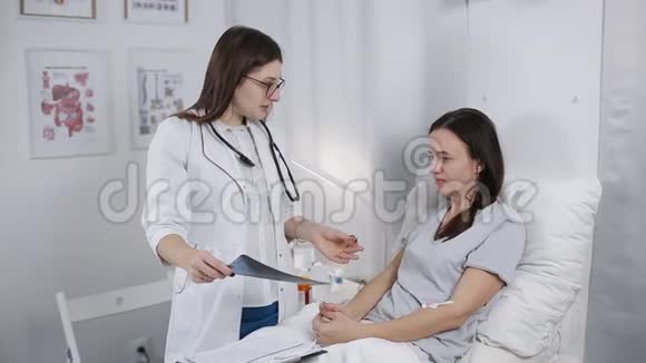 年轻的女医生在医院病房里和一个看x光的病人交谈医生来看病人视频的预览图