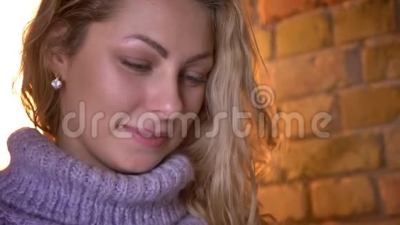 年轻迷人的白种人白种人女性的特写镜头转向镜头在一个舒适的环境中微笑视频的预览图