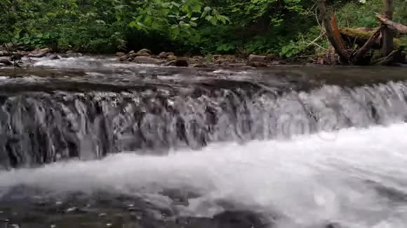 在夏日的黑暗中高山河上的宽瀑布视频的预览图