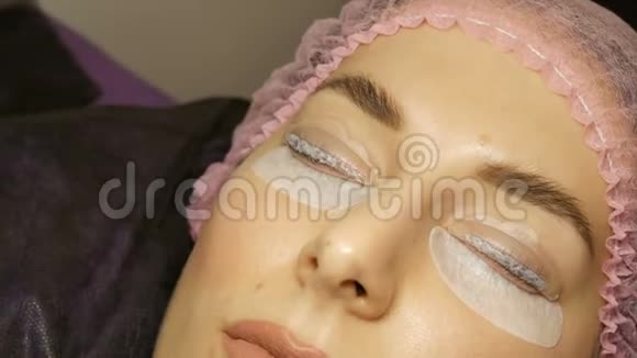 美容院的专业睫毛增强在一个年轻女人的脸上涂上了特殊的睫毛视频的预览图