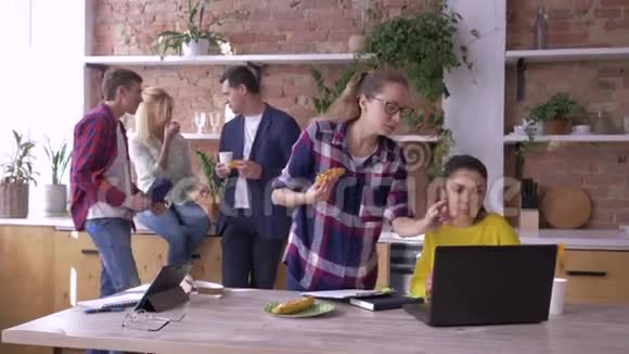 成功的年轻商业伙伴正在厨房里吃平板电脑和笔记本电脑视频的预览图