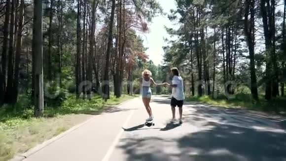 当女孩滑板时男人握着她的手视频的预览图